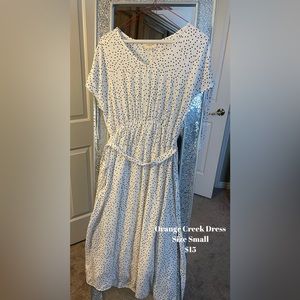 Cute white dress with black polkadots. Hits just below the knees.